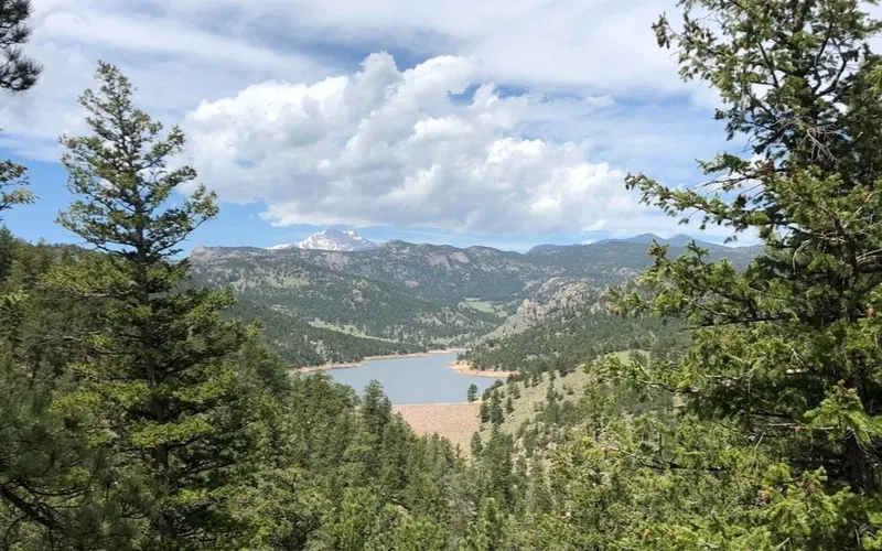 Button Rock reservoir seen through ponderosa pines from the dam trail, snow on the high peaks along the skyline