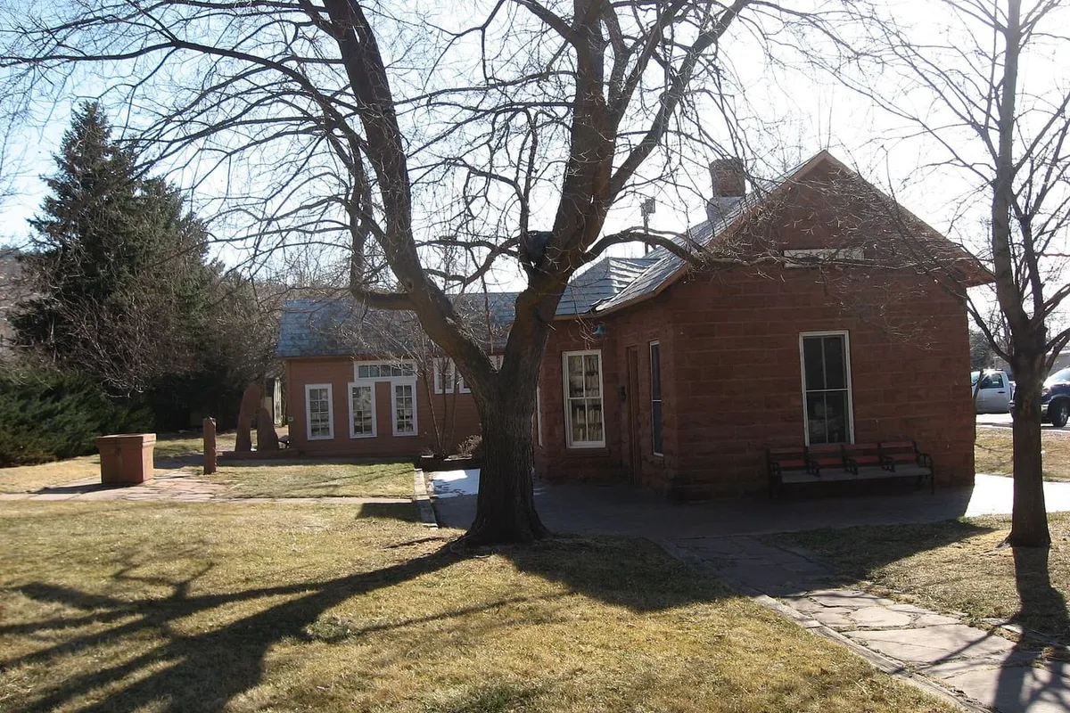 The small red sandstone 1885 Lyons railroad depot with a bench by its door