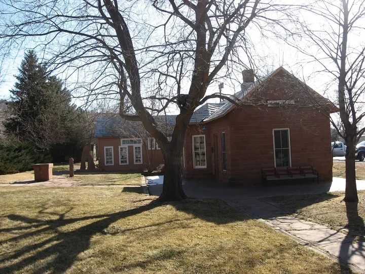 The small red sandstone 1885 Lyons railroad depot with a bench by its door