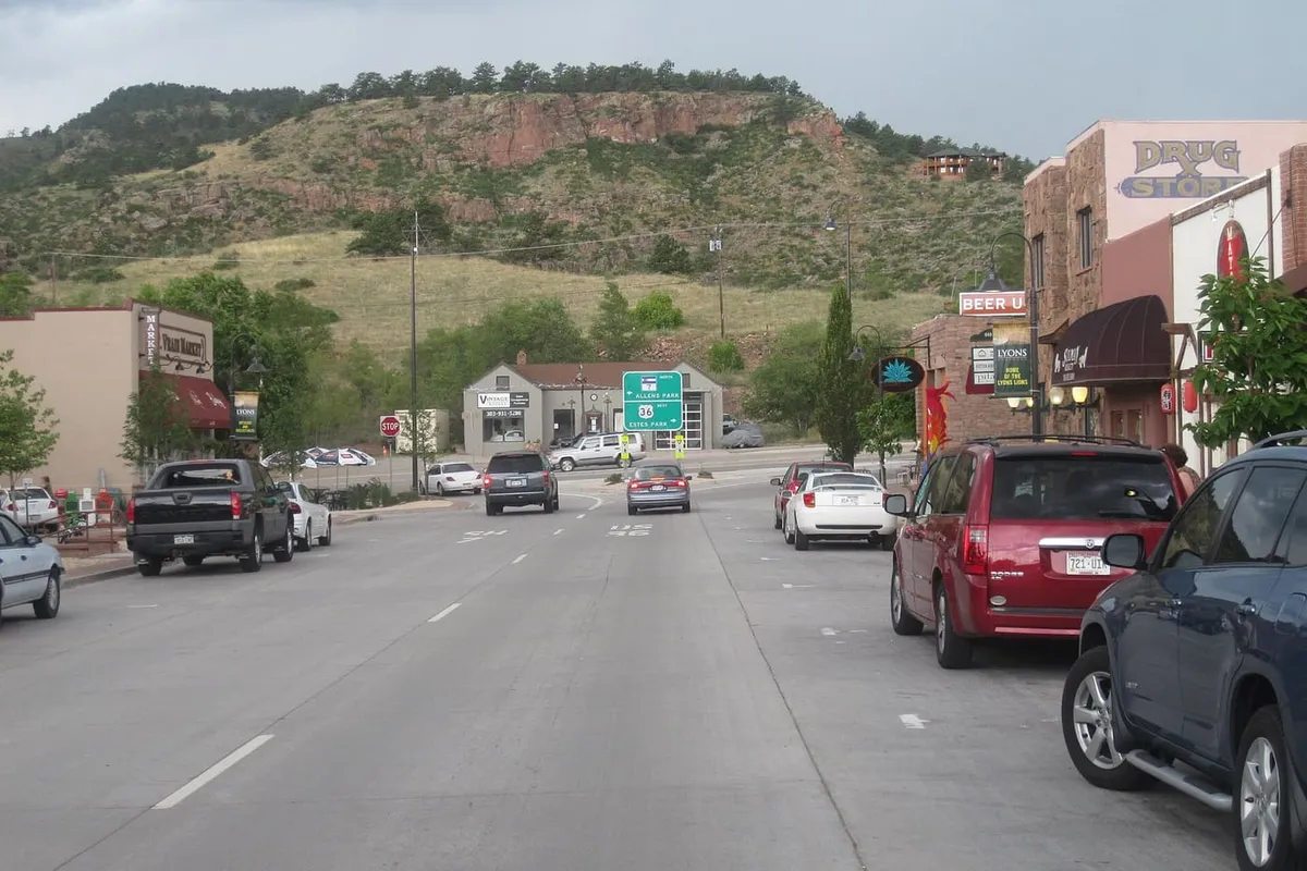 Main Street in Lyons looking west, with the stone drug-store building on the right and the red sandstone hogback behind