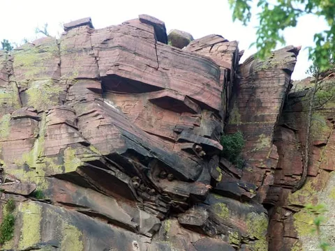 A red sandstone cliff rising straight out of the St. Vrain at the Planet Bluegrass ranch
