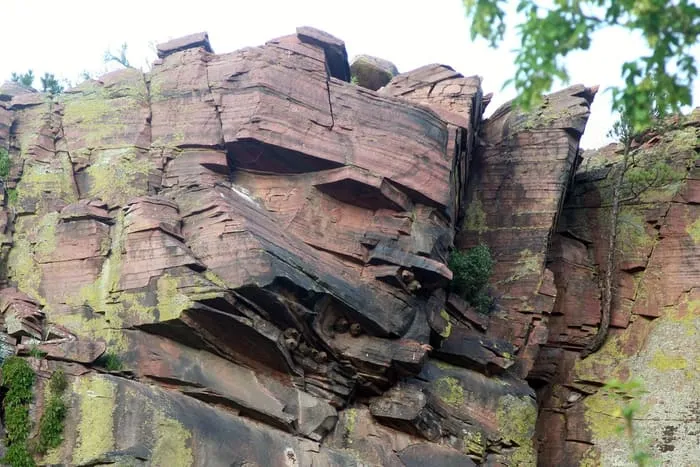 A red sandstone cliff rising straight out of the St. Vrain at the Planet Bluegrass ranch